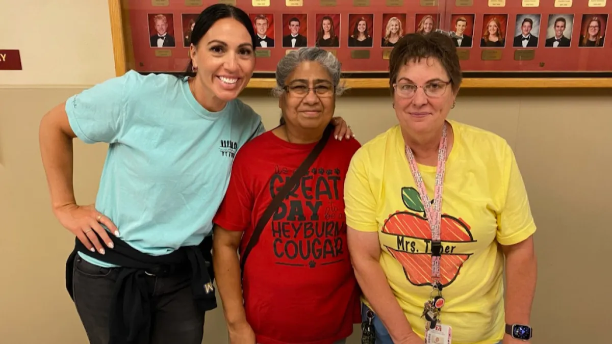three women smiling at the camera 