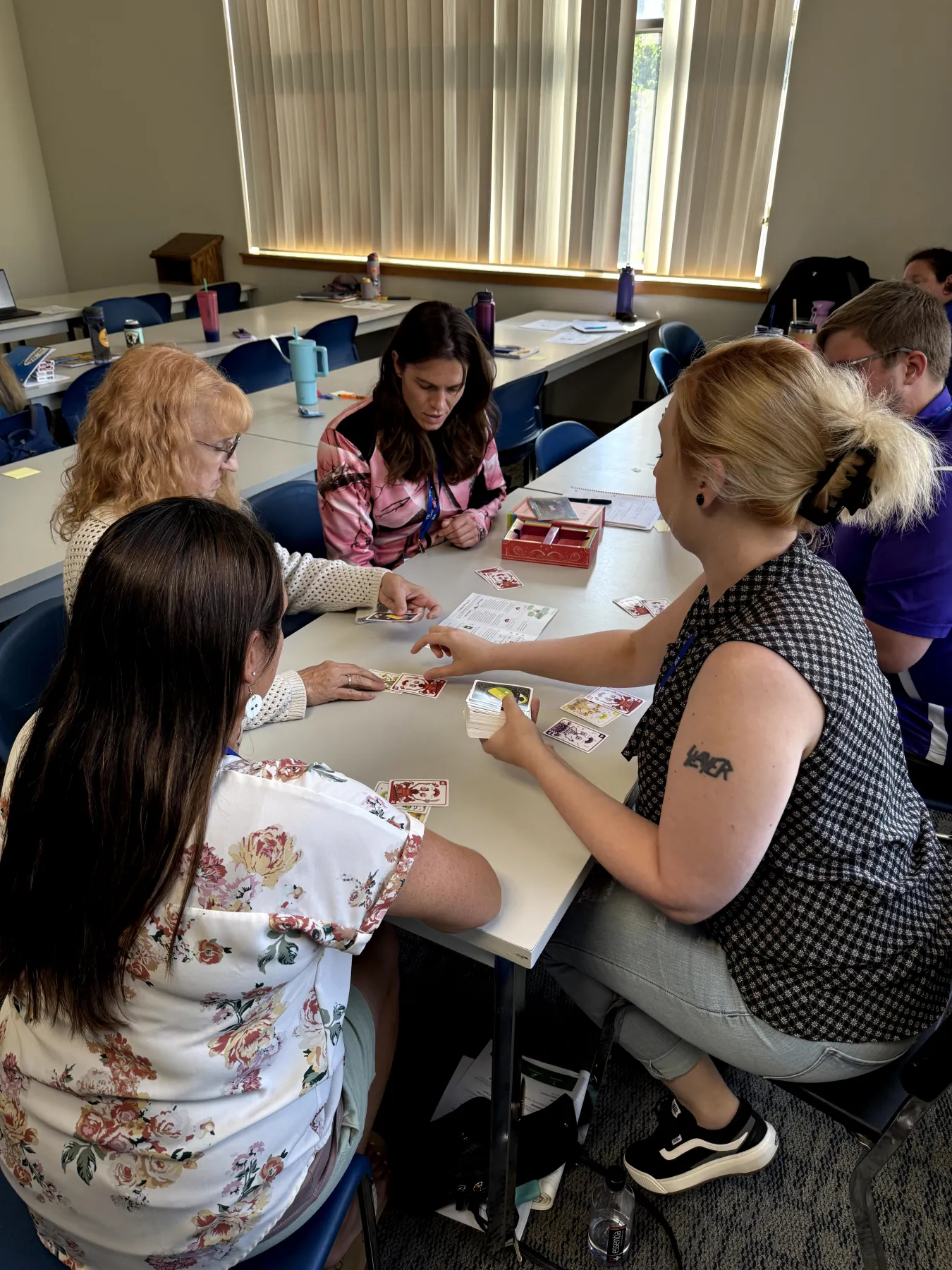 A group of educators plays a card game around a table