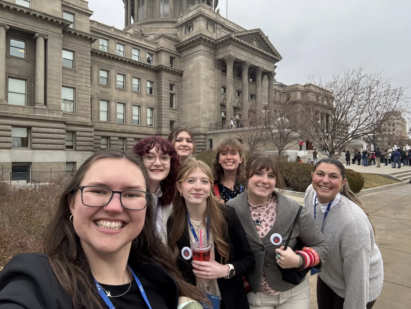 A group of college students poses in front of the Idaho Statehouse