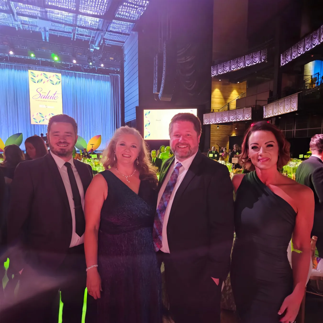 Two men and two women pose at a gala