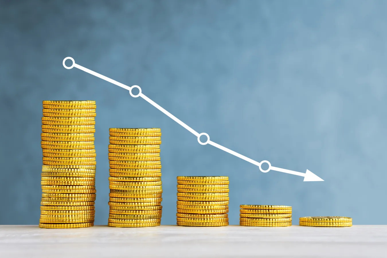A photo illustration of decreasing stacks of coins
