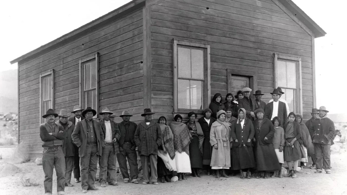 A historic photo of a group of people in front of a building