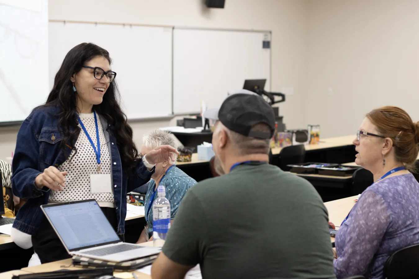 A woman speaks to people in a classroom