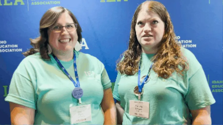 Two women talking and laughing while wearing aqua-green shirts and lanyards