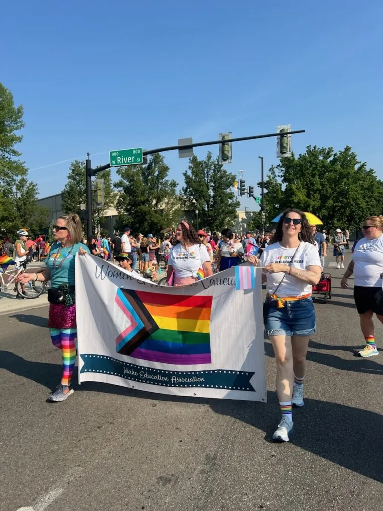 Members of the LGBTQ+ caucus holding a banner and walking in the Boise Pride Parade