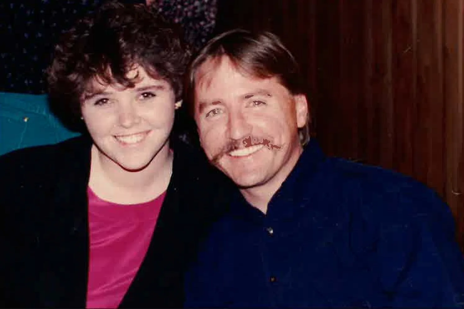 A photo from the early 90s of a young woman with dark hair and a man with a mustach