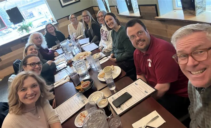 selfie with smiling group at table 