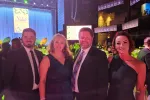 Two men and two women pose at a gala