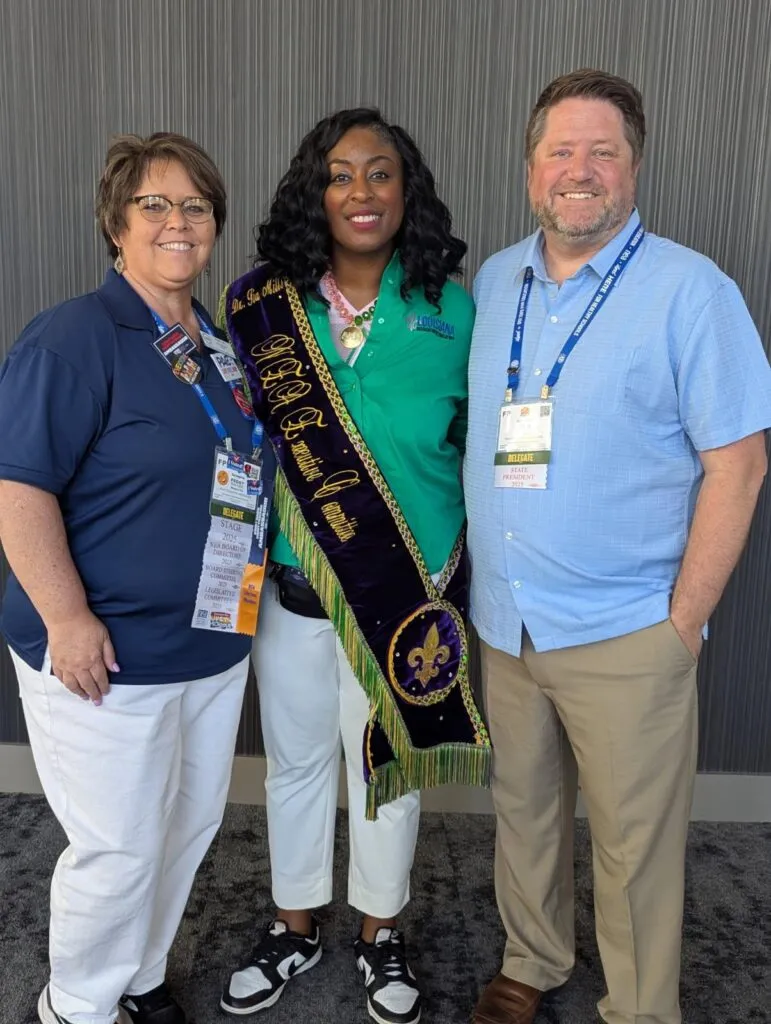 Two women and a man smile at the camera