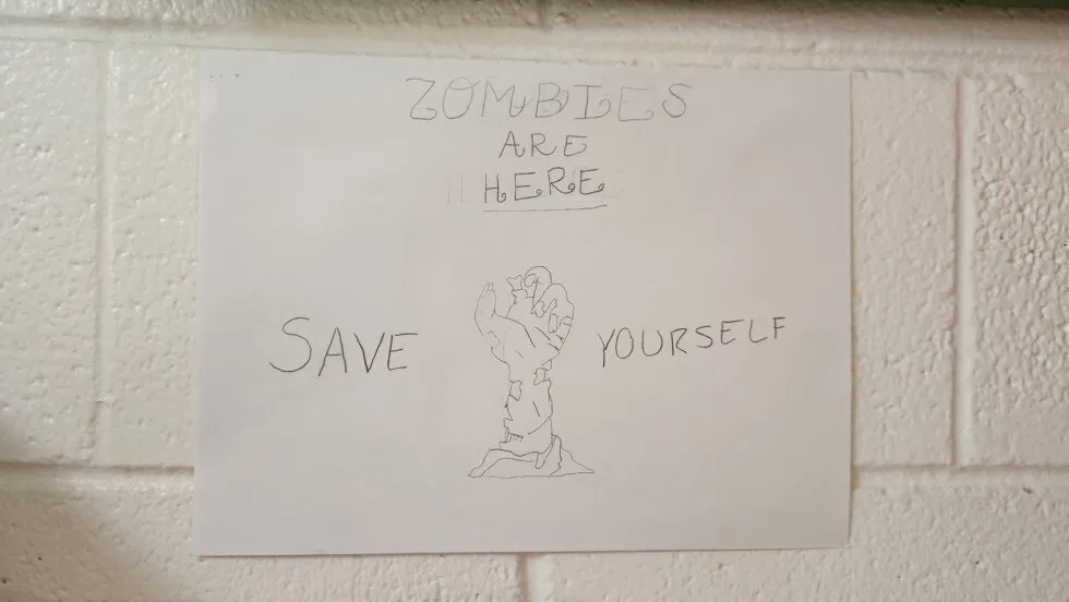 A child's poster about the "zombie apocalypse" that reads "Zombies are here! Save yourself!"