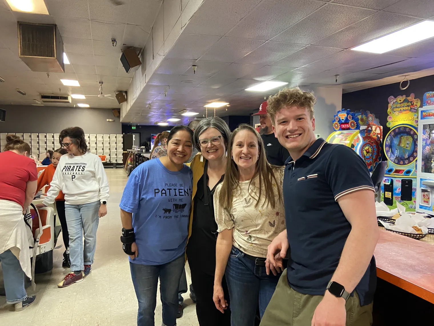 A group of people pose for a photo at a bowling alley
