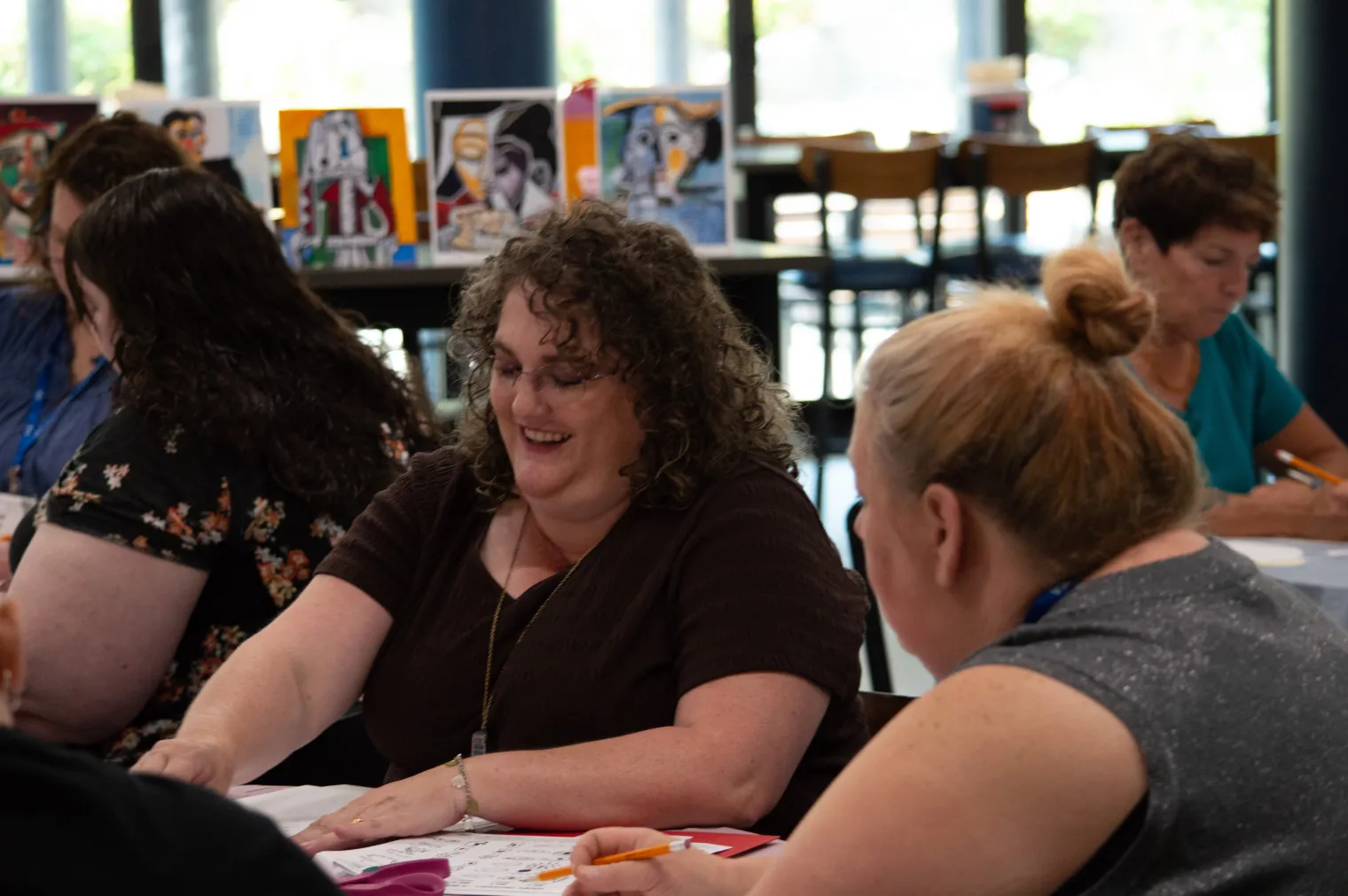 A group of women create art around a table