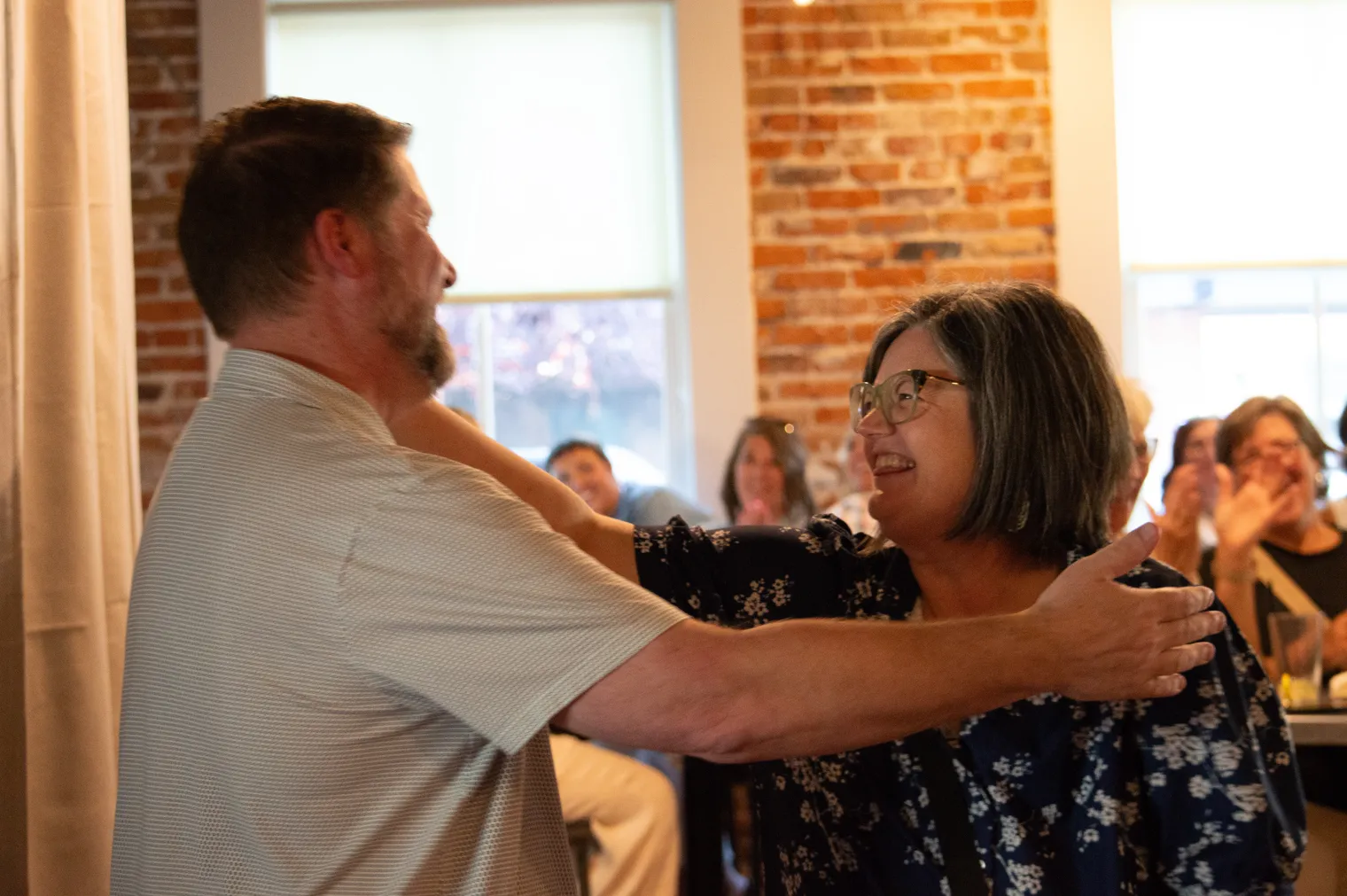 A man and a woman smile and embrace