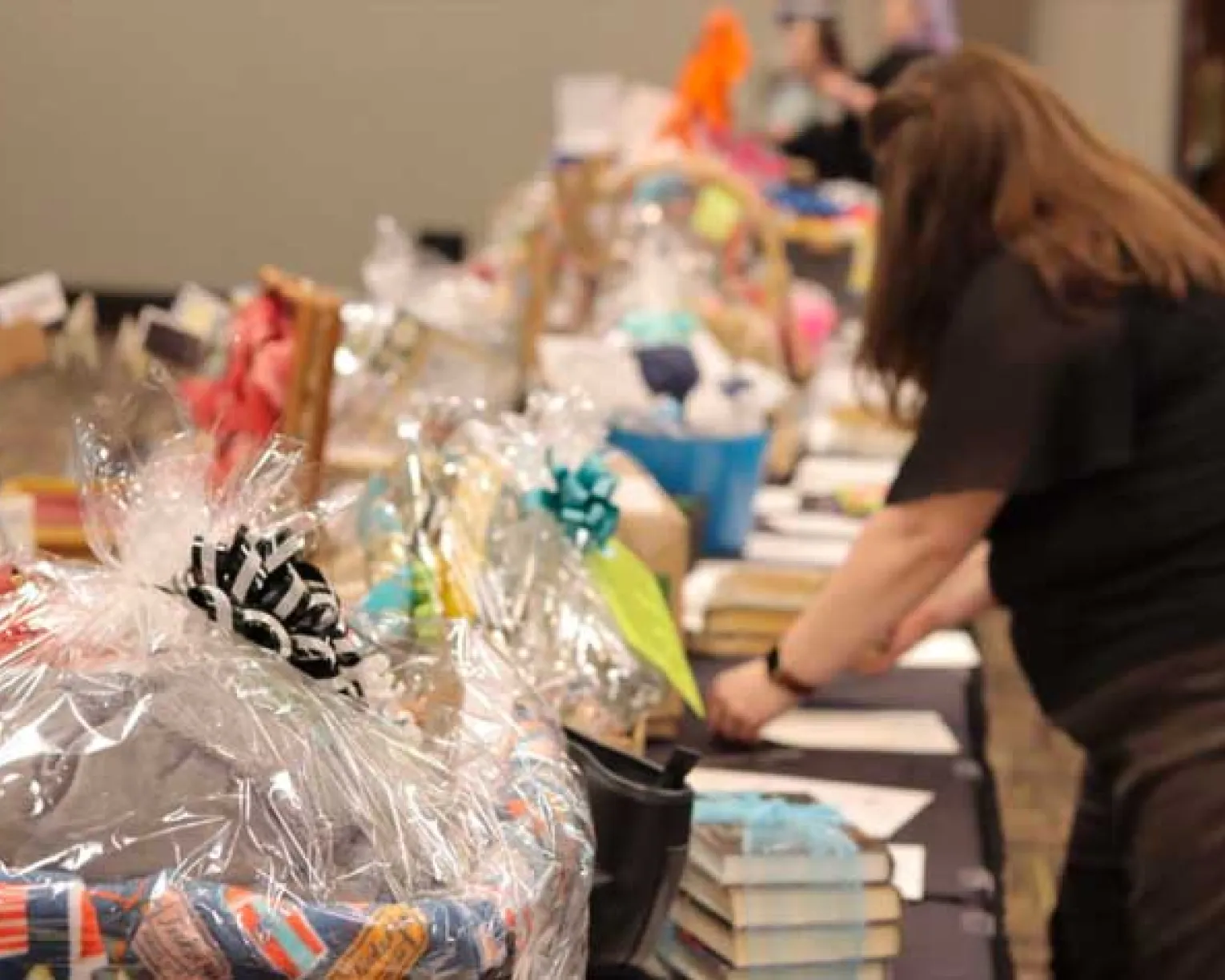 People peruse a row of auction items