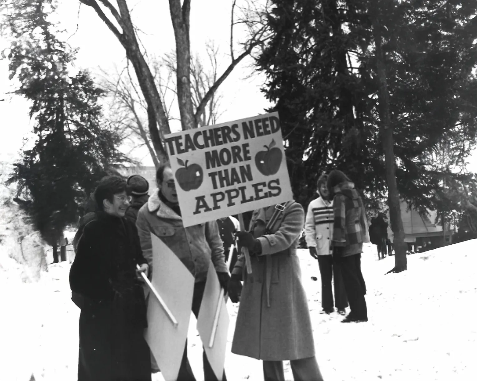 1970s IEA protest with a sign that reads "Teachers need more than apples."