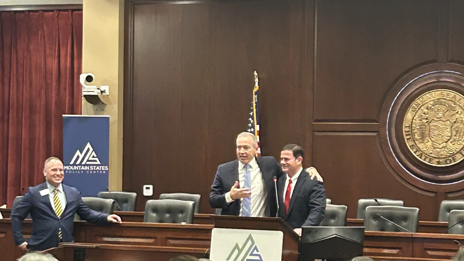 Three smiling men in suits