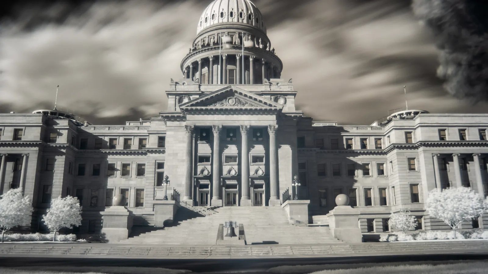 A moody, atmospheric black-and-white photo of the Idaho Statehouse