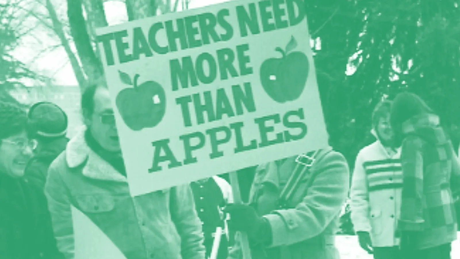 A 1970s photo of a protest and someone holding a sign that reads Teachers Need More Than Apples