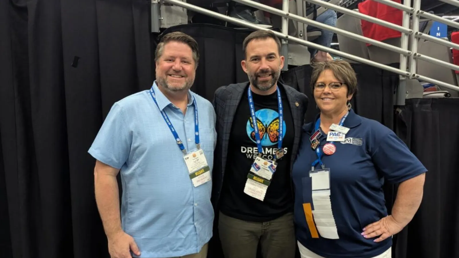 Two men and a woman smile at the camera