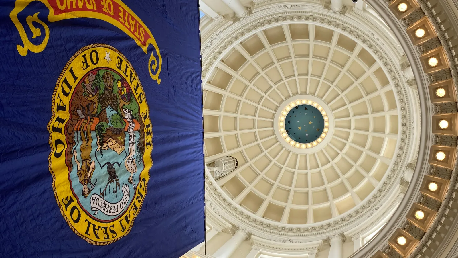 A view looking up at the Idaho Statehouse rotunda with the Idaho flag