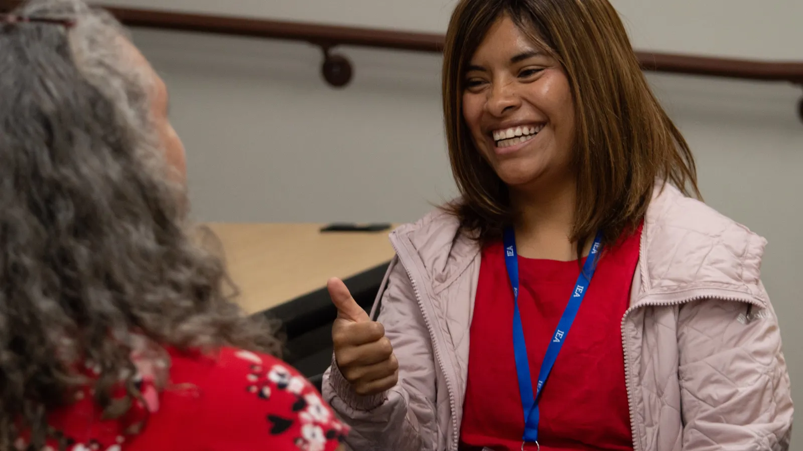 A woman smiles while praciticing American Sign Language