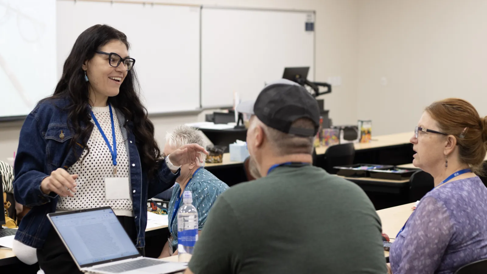 A woman speaks to people in a classroom