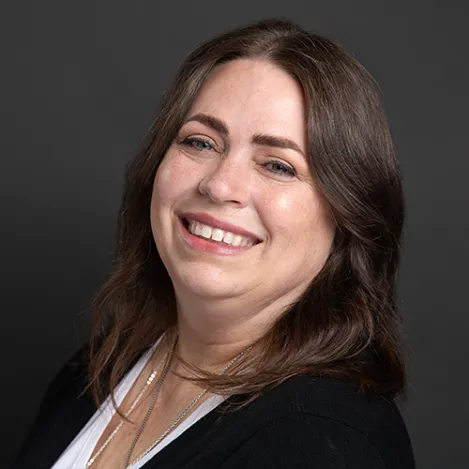 A brown-haired woman smiles into the camera