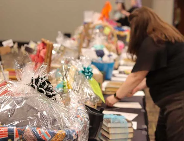 People peruse a row of auction items