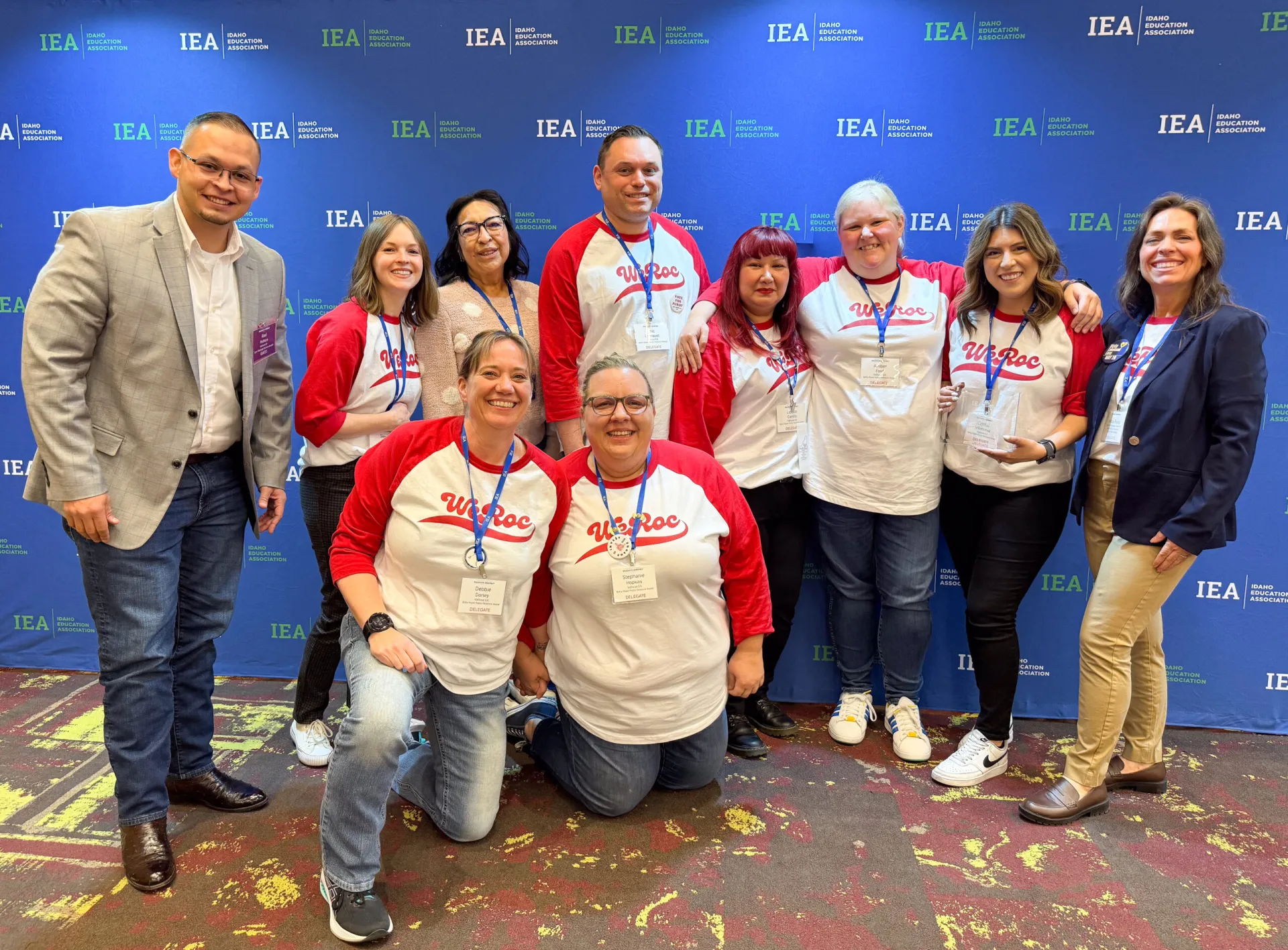 A group of people smiling for the camera against an Idaho Education Association backdrop
