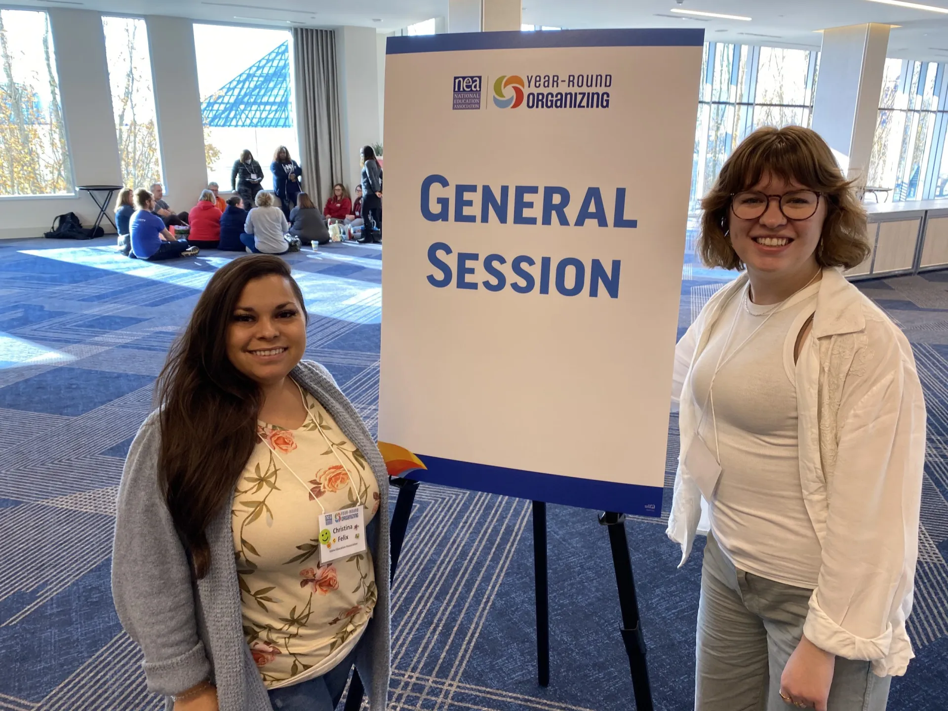Two women flank a sign that says General Session