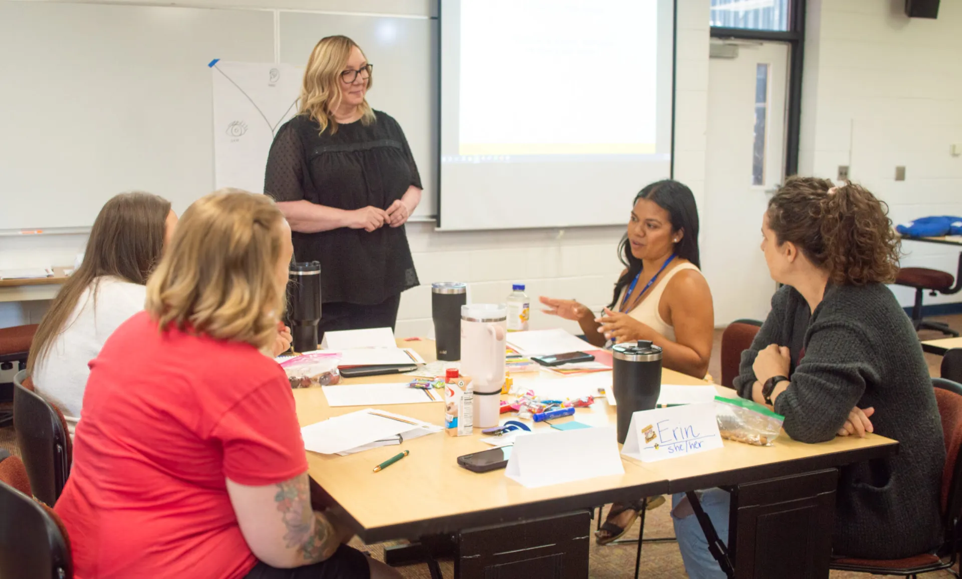 Women gather around a table and talk