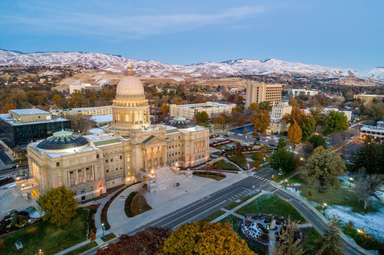 An overhead shot of the Idaho Statehouse with the Boise Foothills in the background. 