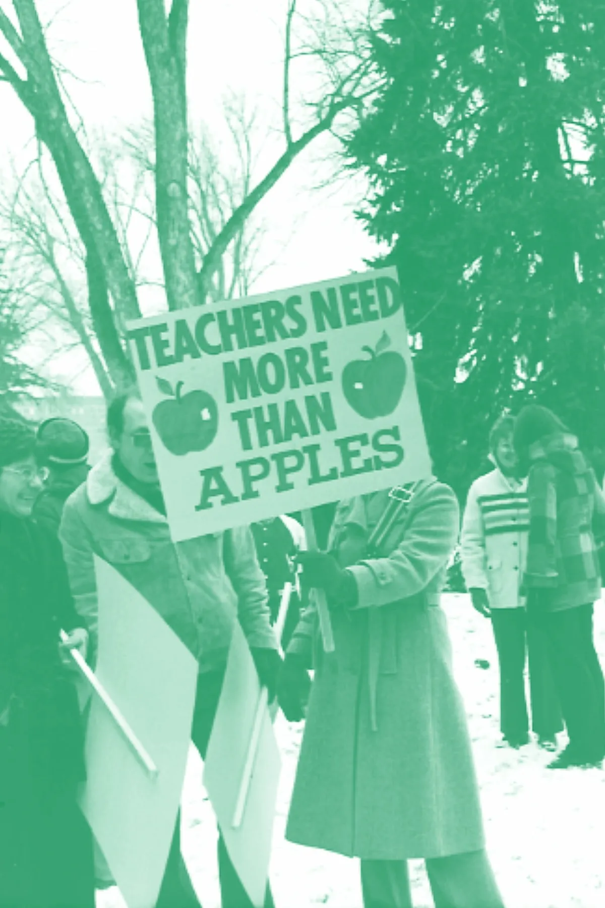 A 1970s photo of a protest and someone holding a sign that reads Teachers Need More Than Apples