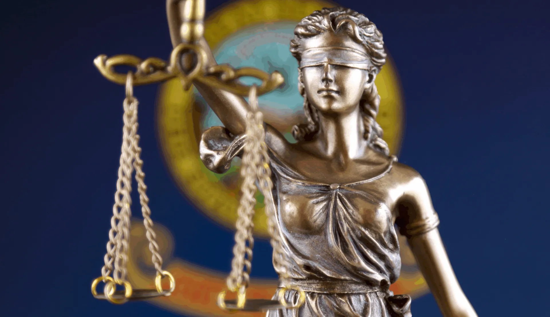Scales of justice are shown with the Idaho flag in the background. 