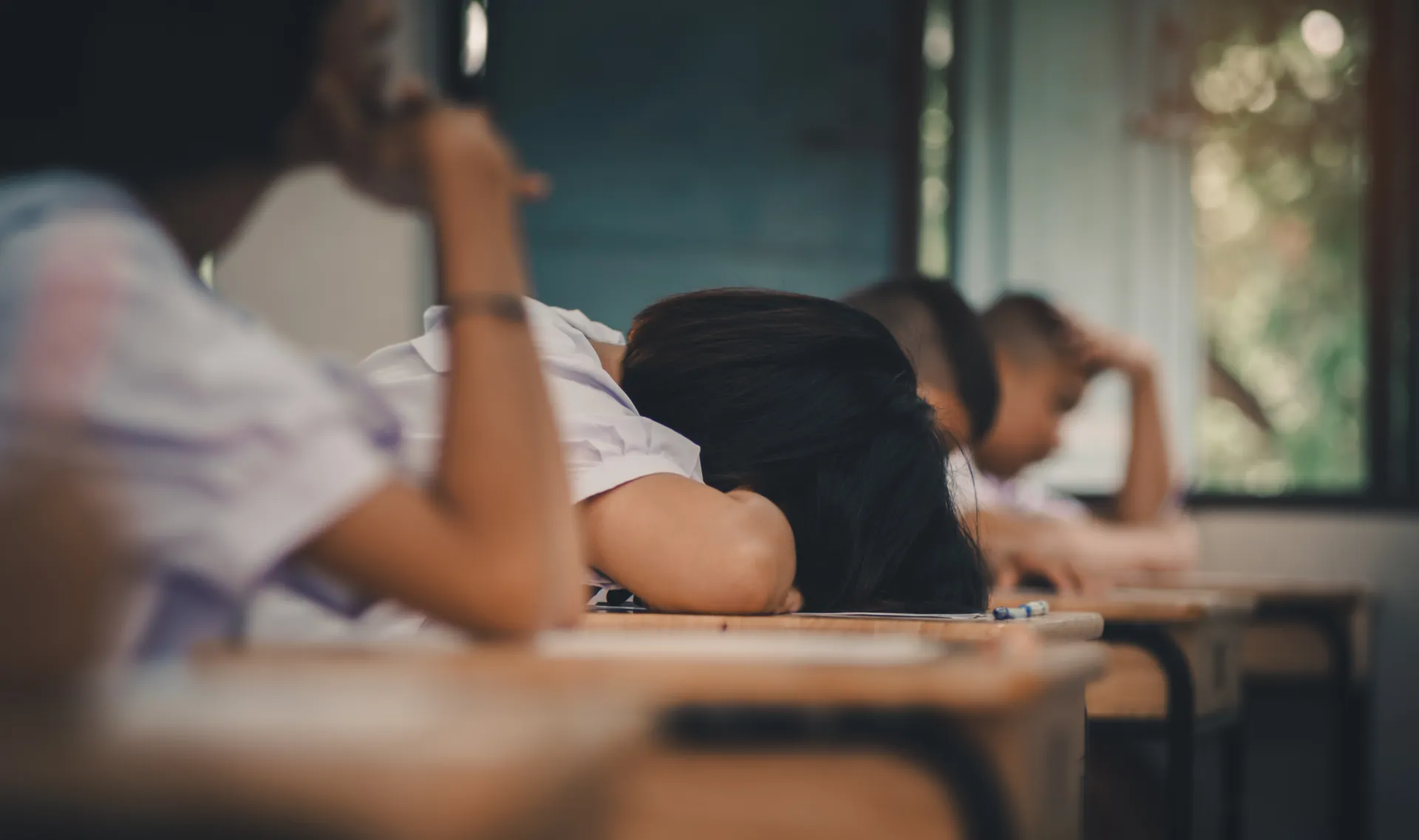 Student lays head down on desk. 