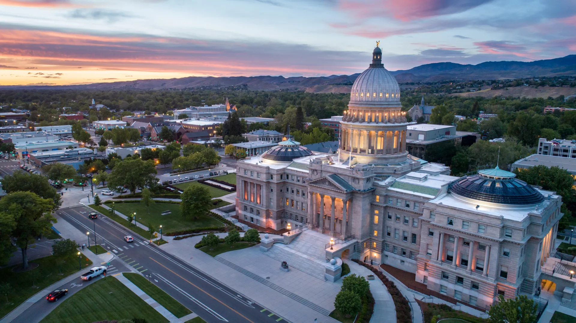 Idaho capitol from the air with a sunset in the distance. 