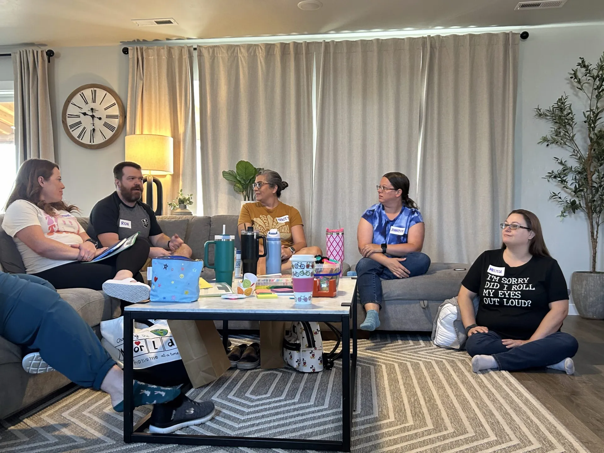 A group of people on couches in a living room have a discussion
