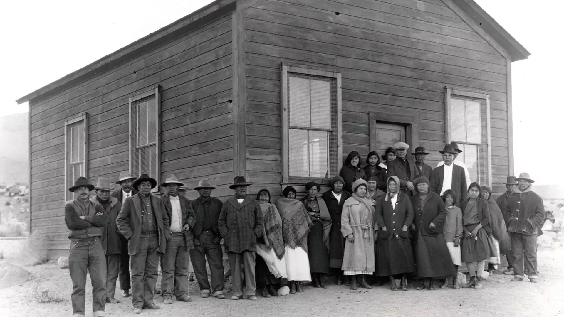 A historic photo of a group of people in front of a building