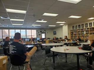 A group of people wearing black sit at round table