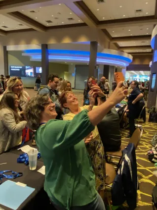 People at a table take selfies