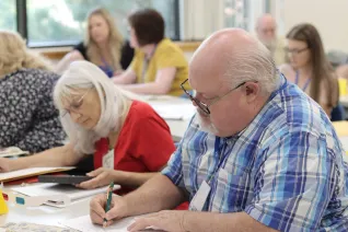 People sit at tables and write