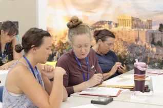Two women sit at a table and talk to each other