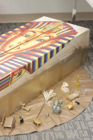 A box with an image of King Tut is surrounded by other Egyptian articles