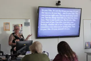 A woman teaches in front of a classroom 