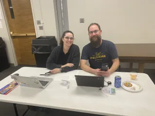 A couple sits side by side while phone banking