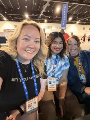 Three women smile at the camera
