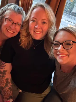 Three women smile for a selfie