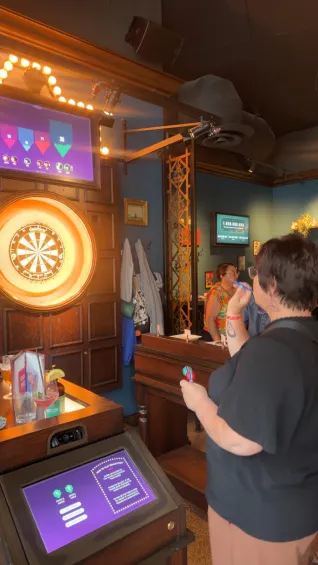 A woman prepares to throw a dart at a dart board