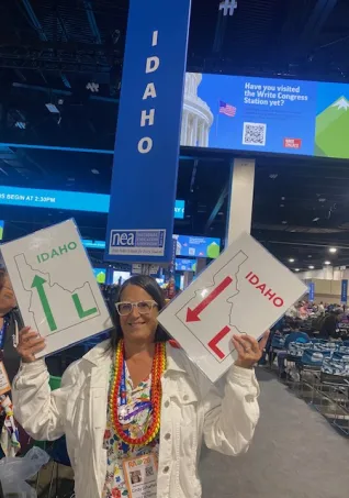 A woman holds two signs that say Idaho