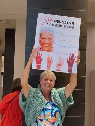 A woman holds up an election poster